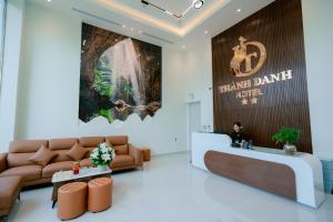 a man sitting at a reception desk in a lobby at Thành Danh Hotel in Dong Hoi