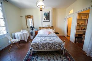 a bedroom with a bed and a table in it at Le Gîte d'Olympe in Cordes-sur-Ciel