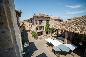 an overhead view of an alley with umbrellas and buildings at Le Gîte d'Olympe in Cordes-sur-Ciel