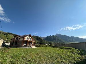 a house on a hill with mountains in the background at Villa Kazbegi in Tkarsheti
