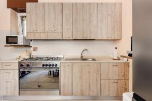 a kitchen with wooden cabinets and a stove top oven at Civico4 - Osteria Varanalle in Ariano Irpino