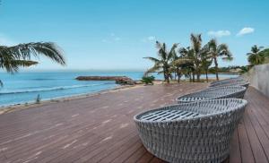 a row of chairs on a boardwalk near the beach at Park Life Tizate in Nuevo Nayarit