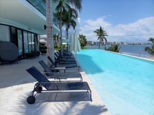 a row of lounge chairs next to a swimming pool at Park Life Tizate in Nuevo Nayarit