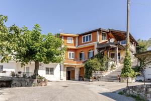 a large orange house with a tree in front of it at Civico4 - Osteria Varanalle in Ariano Irpino