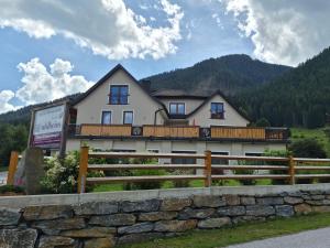 a large white house with a fence in front of it at Pension Waldheim in Mauterndorf
