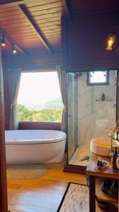 a large bathroom with a tub and a window at IL Rifugio Cabanas in Urubici