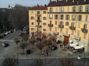 a large yellow building next to a street with cars at La Terrazza Di Arturo Guest House in Turin