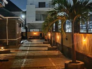 a palm tree in front of a building at night at TwinVilleCove, affordable villas located in Ajah in Aja