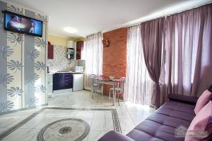 a living room with a purple couch and a kitchen at Apartment on 8 Marta in Mykolaiv