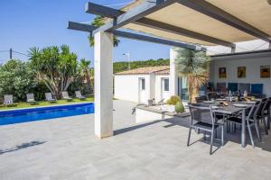 a patio with a table and chairs next to a pool at Villa Terre Des Vins by Villa Plus in Portel-des-Corbières