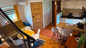 a kitchen with a table and chairs in a room at Zielony Domek u Gosi Kruklanki in Kruklanki +62 photos
