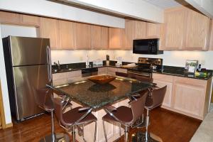 a kitchen with a counter top and a refrigerator at Chateau Dumont Unit 10, Centrally Located Condo, 1 Block from the Gondola in Aspen
