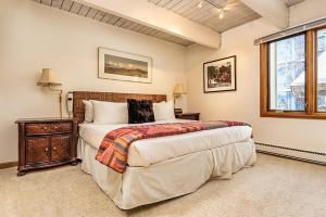 a bedroom with a large bed and a window at Chateau Dumont Unit 10, Centrally Located Condo, 1 Block from the Gondola in Aspen