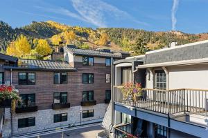 an apartment building with a balcony and mountains in the background at Chateau Dumont Unit 10, Centrally Located Condo, 1 Block from the Gondola in Aspen