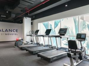 a gym with a row of exercise bikes and computers at Novotel Dubai World Trade Centre in Dubai