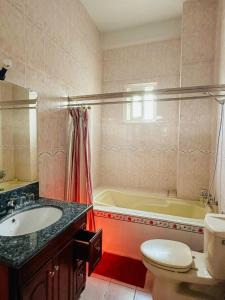 a bathroom with a tub and a toilet and a sink at Khách sạn Nam Sơn in Ấp Lợi Ðủ +16 photos
