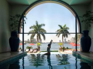 a mermaid is standing in the water in a swimming pool at Sofitel Cairo Nile El Gezirah in Cairo