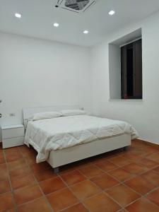 a white bedroom with a bed and a tiled floor at Dream Rooms Palomonte 