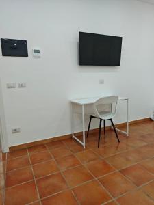 a desk with a chair and a television on a wall at Dream Rooms Palomonte 