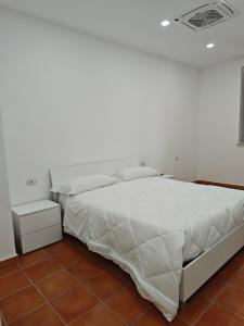 a bedroom with a large bed with white sheets at Dream Rooms Palomonte  +8 photos