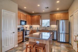 a kitchen with wooden cabinets and a stainless steel refrigerator at Happy Heron in Port Aransas