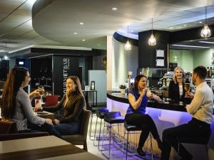 a group of people sitting at a bar at Novotel Reading Centre in Reading