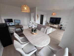 a living room with a table and some white chairs at Superbe appart chic & élegant 2ch - 6 pers in Deuil-la-Barre