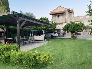 a gazebo with a table and chairs in a yard at Family Home in Amarynthos