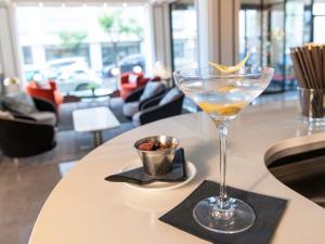 a martini glass sitting on a table in a restaurant at Hotel Plaza Biarritz Plage - Handwritten Collection in Biarritz