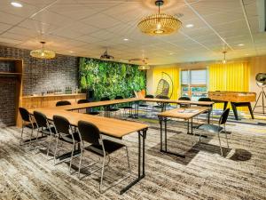 a conference room with tables and chairs and ping pong tables at Mercure Lyon Est Chaponnay in Chaponnay