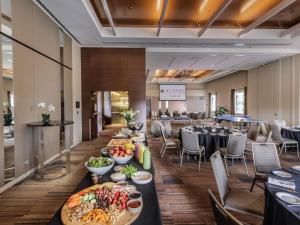 a dining room with tables with plates of food at Pullman Sydney Olympic Park in Sydney