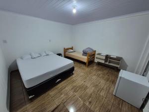 a bedroom with a bed and a chair and a desk at Pousada Maria in Maravilha