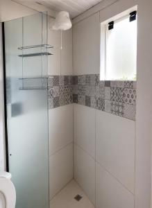 a glass shower in a bathroom with a window at Pousada Cristais do Rosa in Imbituba +41 photos