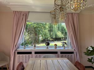 a dining room with a table and a large window at Maison Frieda in Oostkamp