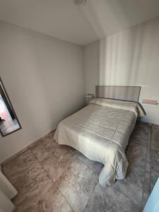 a white bedroom with a bed in the corner at Depto Civora 3 in Villa Regina