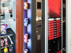 a refrigerator with cans of soda in it at ibis Budget Luxembourg Sud in Livange
