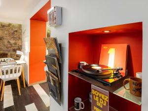 a kitchen with red walls and a counter with a stove at Ibis Styles Strasbourg Centre Gare in Strasbourg