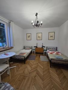 a living room with two beds and a table at Augustówka - letnisko na Wrzosowiskach in Mostówka