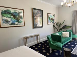 a bedroom with a bed and a green chair and a couch at The Sterling Hotel in Sacramento
