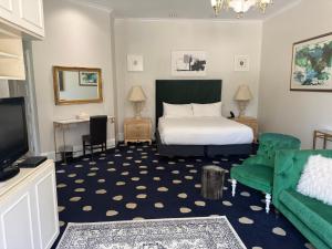 a bedroom with a bed and a couch and a tv at The Sterling Hotel in Sacramento