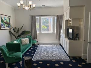 a living room with two green chairs and a television at The Sterling Hotel in Sacramento