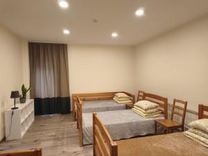 a bedroom with two beds and a table and chairs at Baltakmeņu muiža in Mujani