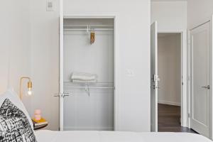 a bedroom with a door leading to a closet at Placemakr Marymount Ballston in Arlington +150 photos