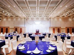 a large banquet hall with blue tables and white chairs at Mercure Yokosuka in Yokosuka