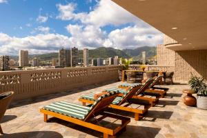 a row of chaise lounges on a balcony at Wayfinder Waikiki - Voted Top 10 Best Hotels in Hawaii! in Honolulu