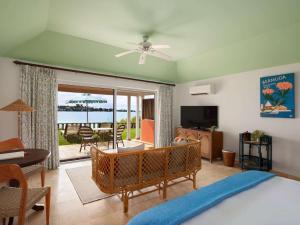 a bedroom with a bed and a living room with a patio at Cambridge Beaches Resort and Spa in Somerset