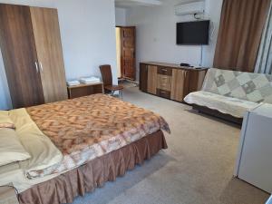 a hotel room with a bed and a couch at Villa 3 papuci in Constanţa