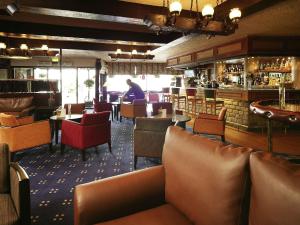 a restaurant with chairs and tables and a bar at Mercure Perth Hotel in Perth