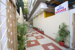 a hotel entrance with plants and a sign on the wall at Hotel Fantacee in Navi Mumbai