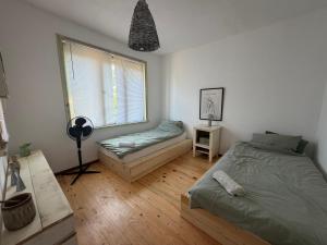 a bedroom with two beds and a window at Privatzimmer auf Pferdehof in Vŭbel